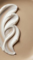 Creamy white cosmetic product swirl on beige background showcasing smooth texture and luxurious skincare formula for beauty and wellness applications.