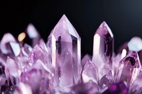 Amethyst crystal points macro shot showing natural purple quartz formation with translucent peaks against dark background, mineral specimen closeup.
