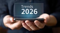 Hands holding smartphone displaying futuristic text trends 2026 on screen, business forecasting and future technology concept for digital marketing.