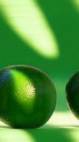 Fresh whole lime with textured skin on green background, dramatic lighting highlights citrus fruit's natural shine and vibrant color. Ideal for food and beverage marketing.