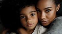 African American mother and daughter share intimate moment, expressing love and connection through gentle embrace. Natural lighting highlights their warm expressions and glowing skin.