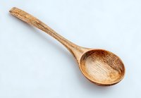 Handcrafted wooden cooking spoon isolated on white background, rustic kitchen utensil made from natural wood with unique grain pattern.