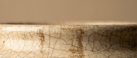 Vintage cracked ceramic bowl with aged patina and weathered texture showing natural wear patterns and antique finish for rustic home decor projects.