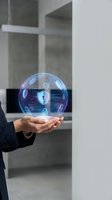 Person in dark business suit holding glowing digital sphere with security icons and lock symbols, representing cybersecurity, data protection, and network safety in modern office environment.