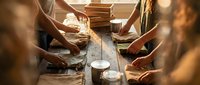 Pottery workshop with hands shaping clay on spinning wheels, artisan craftsmanship and traditional ceramic making process in warm studio lighting.