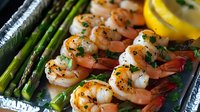 Grilled shrimp skewers with fresh asparagus and lemon slices on aluminum tray, seasoned with herbs and spices, ready to serve for seafood dinner.