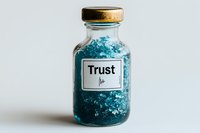 Small glass bottle with cork lid containing blue crystals and labeled "Trust Me" on white background, symbolizing wellness concepts.