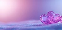 Romantic glass hearts on glittery surface with soft pink and purple bokeh background creates dreamy Valentine atmosphere for greeting cards and love concepts.
