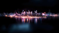Glowing city skyline with vibrant reflections on water surface at night, illuminated skyscrapers and bridge silhouettes create dreamy urban landscape with bokeh effect.