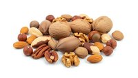 Mixed nuts collection with walnuts almonds hazelnuts pecans on white background isolated for healthy snacking cooking baking recipes nutrition concepts.