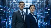 Professional business team of Caucasian man and woman in suits standing confidently in modern data center server room with blue lighting technology background.