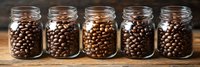 Fresh roasted coffee beans stored in glass mason jars on rustic wooden table, panoramic view showing texture and aroma of premium arabica coffee.