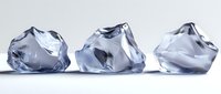 Clear ice chunks arranged in row on white surface with soft shadows and reflections, showcasing frozen crystal formations in cool tones. Perfect for beverage designs.