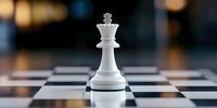 White king chess piece standing alone on checkered board with soft bokeh background, dramatic perspective highlighting strategy and leadership in gameplay.