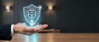 Professional businessman presenting glowing legal protection shield with scales of justice and lock icon, symbolizing law firm security and legal compliance services.