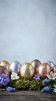 Elegant metallic Easter eggs with floral patterns arranged on moss with spring flowers and grape hyacinths on rustic wood surface against soft background.