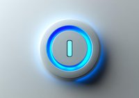 Glowing power button with blue LED light ring on metallic silver surface, modern minimalist design for technology interfaces and smart devices.
