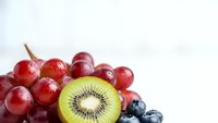 Fresh mixed berries and kiwi slice on white background for healthy eating concepts, smoothie recipes, and nutrition marketing materials.