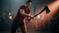 Strong athletic man swinging axe in dramatic lighting, fitness workout training session in industrial gym setting for strength building exercise routine.