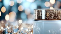 Luxurious cosmetic cream jar with golden glitter sparkles on blurred bokeh background, elegant skincare product photography for beauty industry.