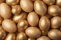 Golden and natural chicken eggs with glitter sparkle pattern creating luxurious Easter composition on brown background for holiday decoration.