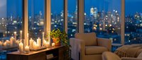 Cozy evening living room with candles and city lights view through large windows. Warm ambient lighting creates relaxing atmosphere for home decor concepts.