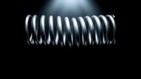 Metal coil spring with chrome finish on dark background with dramatic lighting for industrial and mechanical design projects.