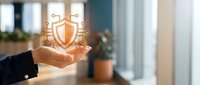 Businessperson holding glowing shield with security icons, representing data protection, cybersecurity solutions, and digital safety for enterprise networks and online defense systems.