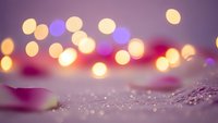 Soft purple bokeh lights creating dreamy atmosphere with sparkling texture in foreground for festive backgrounds and romantic designs.