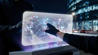 Businessman in dark suit touching holographic globe display with digital network connections and data visualization on transparent screen at night with illuminated office building in background.