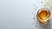 Glass of golden honey with scattered drops on light gray background, top view composition with copy space for text. Minimalist food photography.