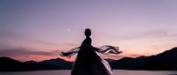 Woman silhouette dancing at sunset lake with flowing dress and crescent moon. Peaceful evening meditation and freedom concept for wellness branding.