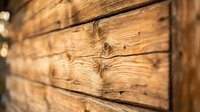 Close-up of natural wood log cabin wall showing rustic timber construction with visible grain patterns and joints for architectural design projects.
