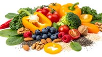 Fresh colorful vegetables, fruits, nuts and seeds arranged on white background. Healthy organic food ingredients for balanced nutrition and cooking.