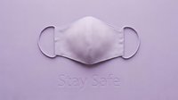 Fabric face mask on lavender background with Stay Safe text, health protection concept for pandemic awareness and safety campaigns.