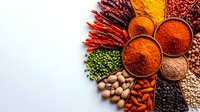 Vibrant collection of aromatic spices, legumes and nuts arranged on white background. Colorful Indian cooking ingredients with paprika, turmeric powder and dried chilies.