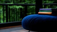 Minimalist meditation corner with blue round cushion and stacked books against blurred green forest background, creating zen atmosphere for mindfulness practice.