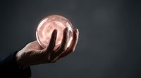 Hand holding glowing pink energy sphere with magical light effects against dark background for fantasy and supernatural concepts.