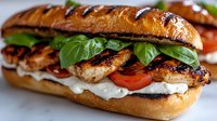 Grilled chicken sandwich with fresh spinach leaves, tomato slices, and creamy sauce on toasted brioche bun, close-up view showing juicy meat texture.