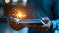 Magical glowing sparkles emanating from open book pages held in hands against dark background, creating mystical reading atmosphere and storytelling concept.