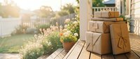 Stacked cardboard boxes and packages on wooden porch with garden view, representing delivery, shipping, moving, and e-commerce logistics for retail and business use.