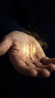 Open palm holding glowing golden human figures with magical light particles dispersing against dark background, representing teamwork, leadership, human resources, and business growth concepts.