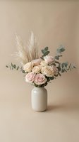 Elegant floral arrangement with soft pink roses, pampas grass and eucalyptus in white ceramic vase on neutral beige background for home decor and styling.