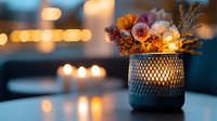 Cozy autumn evening scene with decorative candle holder featuring dried flowers and warm glowing lights creating peaceful ambiance for home decor and relaxation.