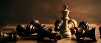 Chess king piece standing victorious among fallen pawns on wooden board symbolizing leadership strategy and business success in competitive environment.
