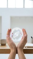 Woman holding glowing compass orb with navigation symbol, representing direction, guidance, and digital technology in modern workspace environment.