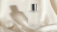 Elegant frosted glass perfume bottle with silver cap on soft cream silk fabric background for luxury cosmetics and fragrance branding.