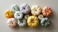 Colorful pastel pumpkins in soft muted tones arranged on white background. Seasonal autumn decor featuring yellow, pink, blue, and orange gourds creates modern harvest display.