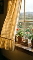 Cozy cottage window with yellow gingham curtains, potted flowers, and countryside landscape view. Rustic interior design with natural light and vintage home decor elements.