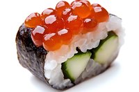 Fresh salmon roe sushi roll with cucumber and rice wrapped in nori seaweed, close-up view showing bright orange caviar pearls on white background.